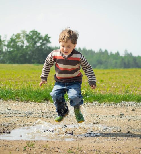 Kindje dat in een plas springt