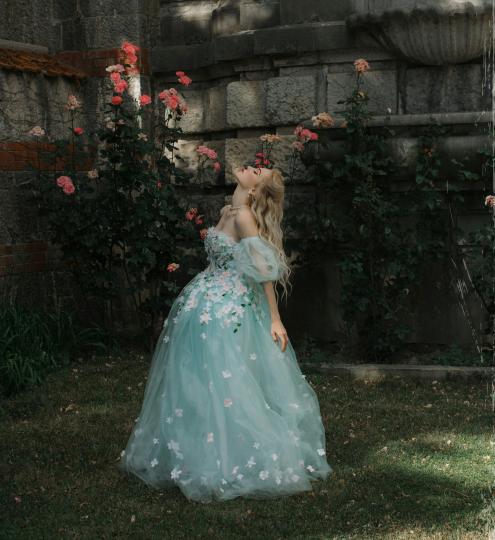 Prinses met blauwe jurk in een tuin