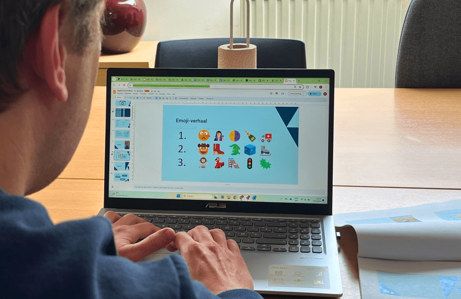 Persoon voor een laptopscherm waarop een presentatie te zien is dat een emoji-verhaal toont.
