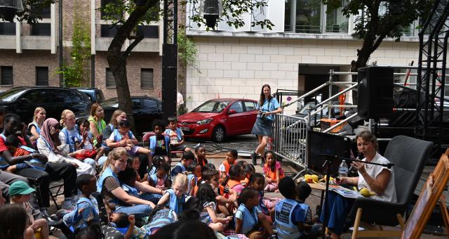 Kim Crabeels leest voor aan een diverse groep kinderen